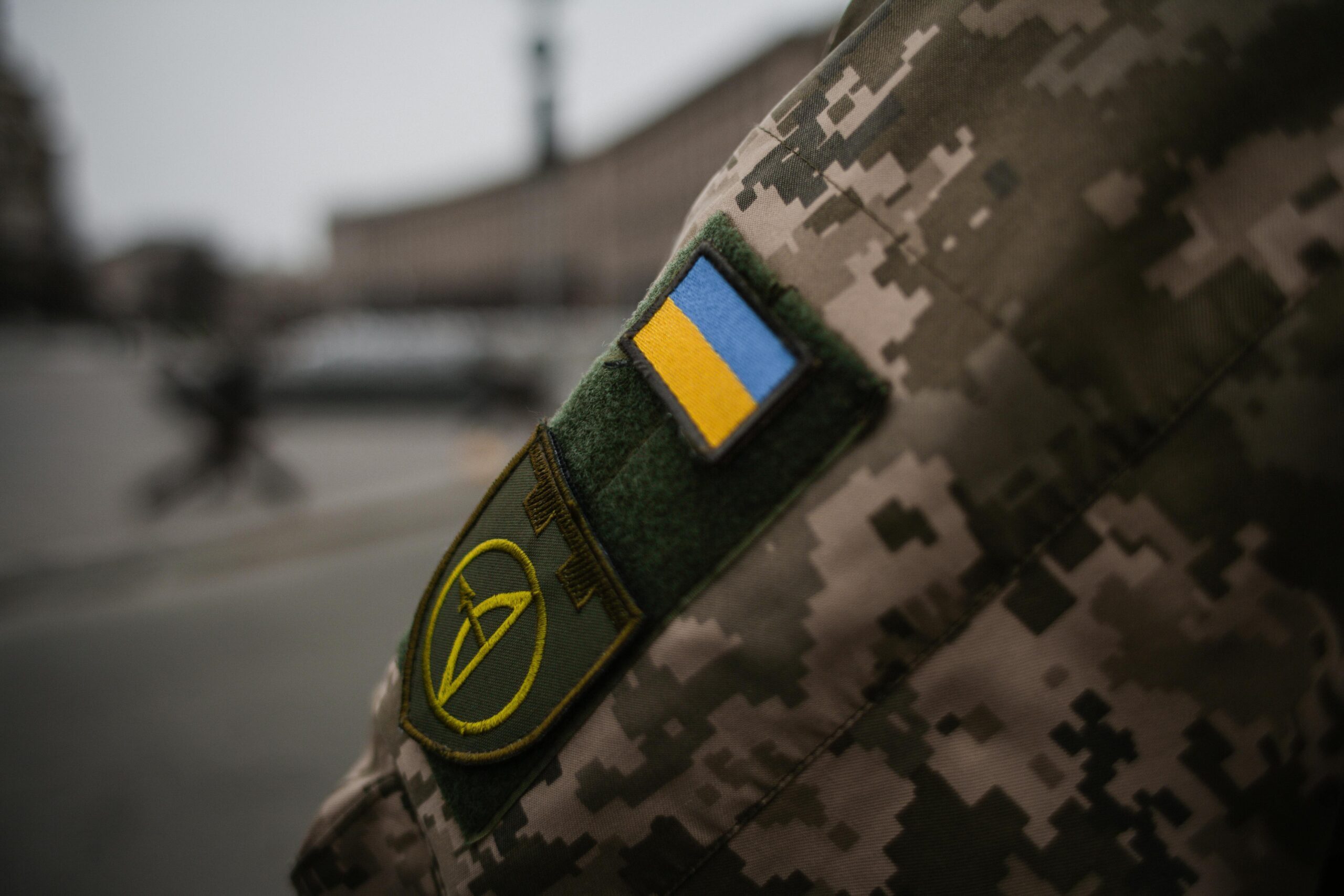 Військовий адвокат у Києві та Київській області Detailed shot of Ukrainian military uniform with flag patch, symbolizing national pride.